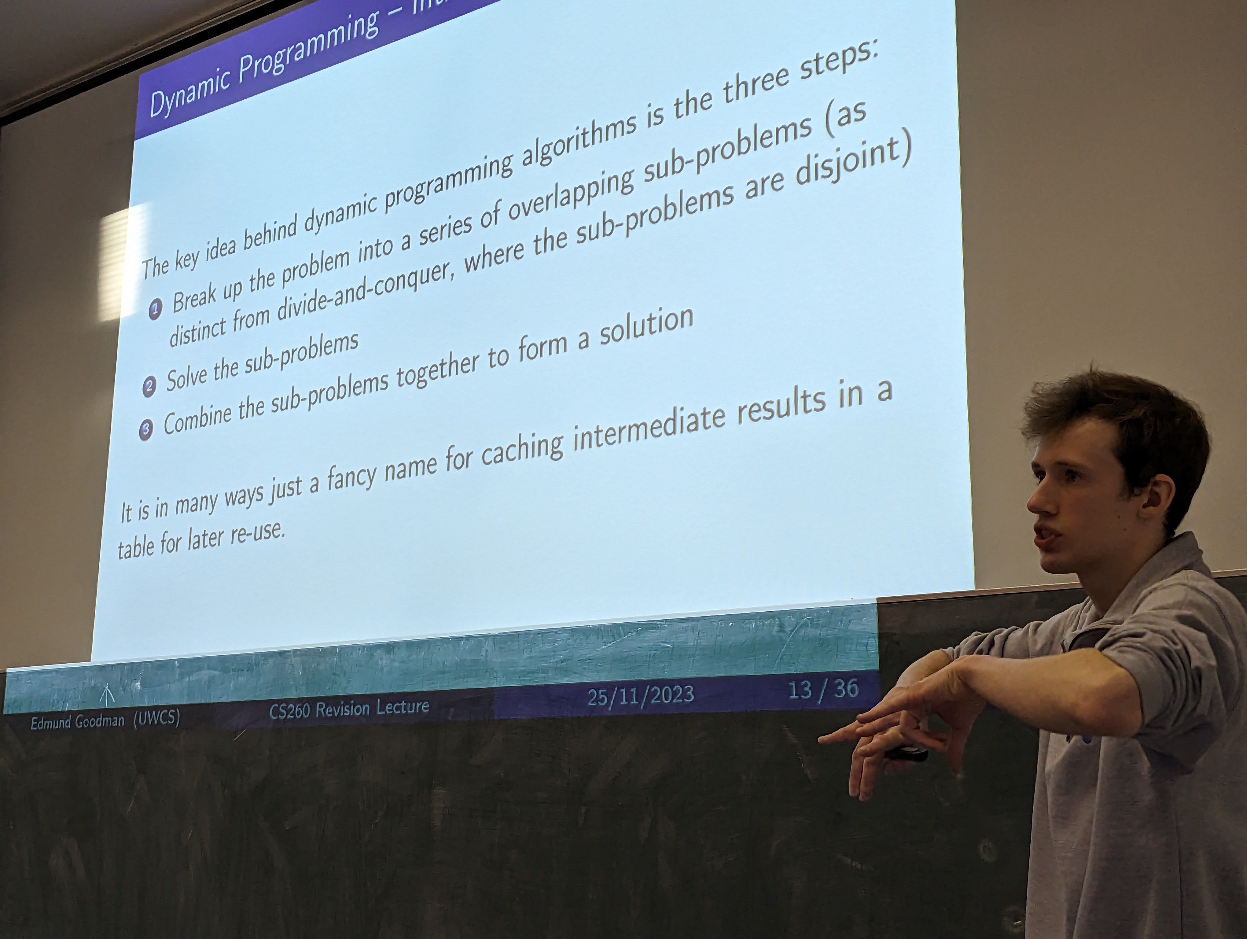 A photo of me explaining Dynamic Programming using a Beamer slide.